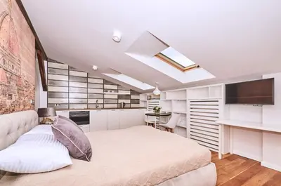 a bedroom with a large bed and a kitchen at Chodkiewicza 10 (A) - cozy studio by Homeprime in Kraków