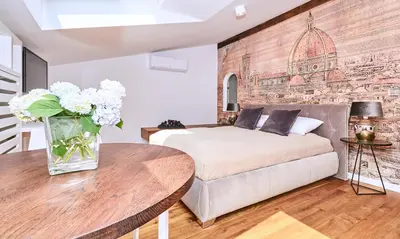 a bedroom with a bed and a table with a vase of flowers at Chodkiewicza 10 (A) - cozy studio by Homeprime in Kraków