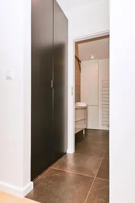 a hallway with a black door and a bathroom at Chodkiewicza 10 (B) - cozy studio by Homeprime in Kraków