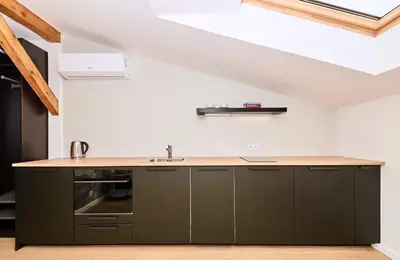 a kitchen with dark green cabinets and a sink at Chodkiewicza 10 (B) - cozy studio by Homeprime in Kraków
