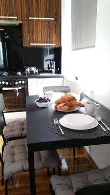 a table with a plate of food on it in a kitchen at Royals Flower Apartments III in Kraków
