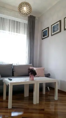 a white bench in a living room with a couch at Royals Flower Apartments III in Kraków