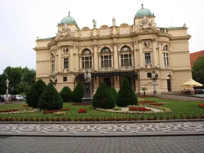 a large building with a garden in front of it at Royals Flower Apartments III in Kraków