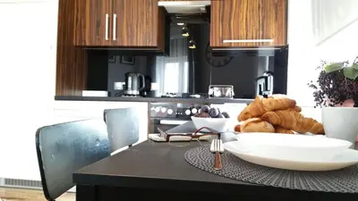 a kitchen with a table with a bowl of bread at Royals Flower Apartments III in Kraków