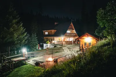 a large wooden house at night with lights at Góralska Willa in Nowy Targ