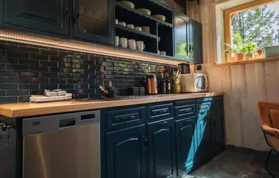 a kitchen with blue cabinets and a dishwasher at Góralska Willa in Nowy Targ