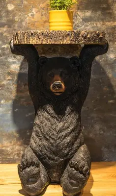 a statue of a bear sitting under a table at Góralska Willa in Nowy Targ