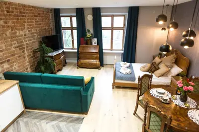 a living room with a blue couch and a brick wall at Luxury in the Heart of the Old Town in Kraków