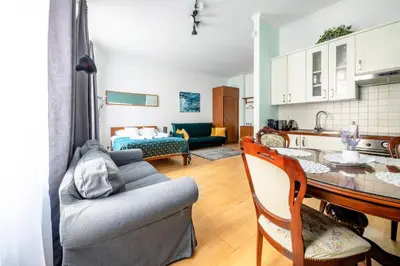 a kitchen and living room with a couch and a table at Luxury in the Heart of the Old Town in Kraków