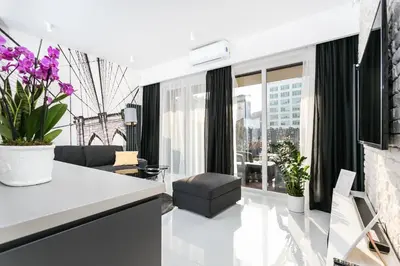 a living room with a view of a building at City of the Kings Arianska Garden in Kraków