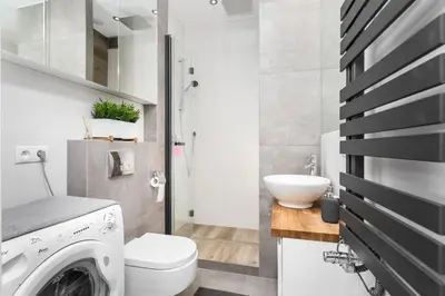 a bathroom with a washing machine and a sink at City of the Kings Arianska Garden in Kraków