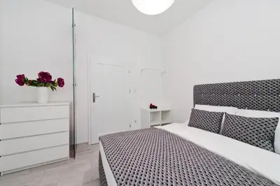a bedroom with a black and white bed and a dresser at Apartament Solny Centrum Wieliczka 11 in Wieliczka