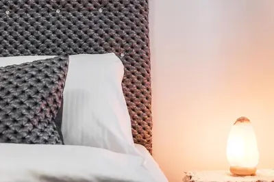 a bed with a black headboard and a lamp on a table at Apartament Solny Centrum Wieliczka 11 in Wieliczka