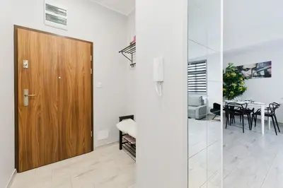 a hallway with a wooden door and a dining room at Apartament Solny Centrum Wieliczka 11 in Wieliczka