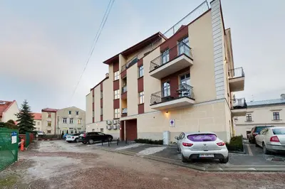 a apartment building with cars parked in a parking lot at Apartament Solny Centrum Wieliczka 11 in Wieliczka