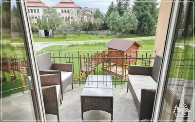 a balcony with chairs and a playground in the background at Przystanek Rabka - Apartamenty w centrum in Rabka