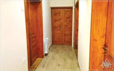 an empty hallway with wooden doors and wooden floors at Przystanek Rabka - Apartamenty w centrum in Rabka