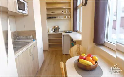 a kitchen with a bowl of fruit on a table at Przystanek Rabka - Apartamenty w centrum in Rabka