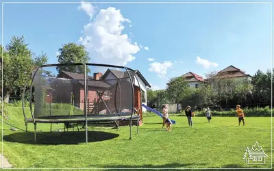 a group of children playing on a trampoline in a park at Przystanek Rabka - Apartamenty w centrum in Rabka