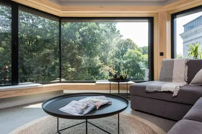 a living room with a table and a large window at Academia Apartments in Kraków
