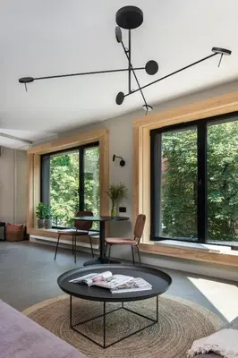 a living room with a table and chairs and windows at Academia Apartments in Kraków