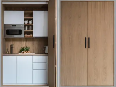 a kitchen with white cabinets and a microwave at Academia Apartments in Kraków