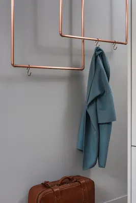 a coat hanging on a rack next to a suitcase at Academia Apartments in Kraków