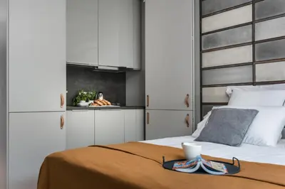 a bedroom with a bed and a kitchen at Academia Apartments in Kraków
