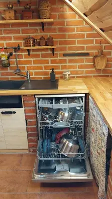 an open dishwasher in a kitchen under a counter at Mountain cabin in Pcim