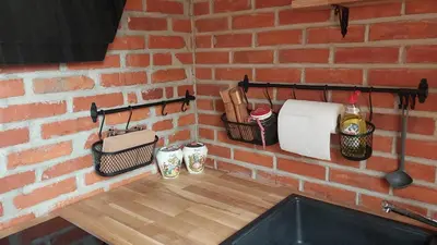 a brick wall with a counter with towels and utensils at Mountain cabin in Pcim