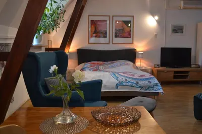 a living room with a bed and a table at Akwarela I in Kraków