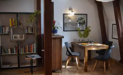 a room with a table and chairs and a book shelf at Akwarela I in Kraków