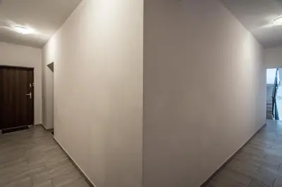 an empty corridor with a white wall at Modern Apartment close to the center by Krakow Home in Kraków