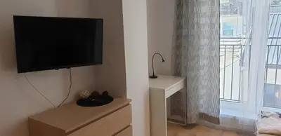 a living room with a flat screen tv and a window at Modern Apartment close to the center by Krakow Home in Kraków