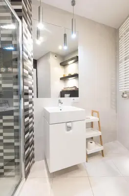 a white bathroom with a sink and a shower at Apartments Olit Bajeczna in Kraków