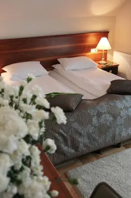 a bedroom with a bed with white flowers on it at Villa Julia in Kraków