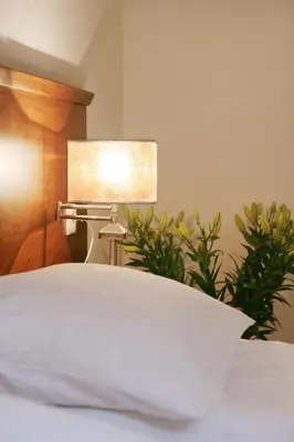 a bed with a white pillow and a lamp at Villa Julia in Kraków