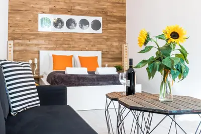 a bedroom with a bed and a vase with a sunflower at Cracow Best Location Apartment with Garden by Cozyplace in Kraków