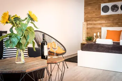 a dining table with a bottle of wine and a vase of flowers at Cracow Best Location Apartment with Garden by Cozyplace in Kraków