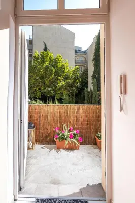 an open door to a patio with pink flowers at Cracow Best Location Apartment with Garden by Cozyplace in Kraków