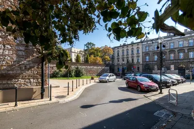 a brick building with a car parked in front of it at Cracow Best Location Apartment with Garden by Cozyplace in Kraków