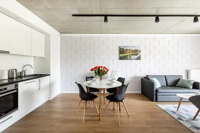 a kitchen and living room with a table and chairs at River Side Residence nr 1m7 in Oświęcim