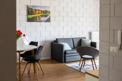 a living room with a couch and a table and chairs at River Side Residence nr 1m7 in Oświęcim