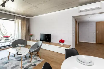 a living room with tables and chairs and a tv at River Side Residence nr 1m7 in Oświęcim