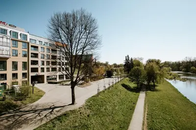 a walkway next to a building next to a river at River Side Residence nr 1m7 in Oświęcim