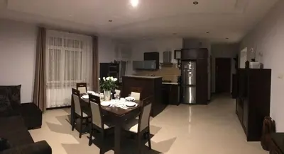 a kitchen and dining room with a table and chairs at Apartment Family Krakow in Kraków