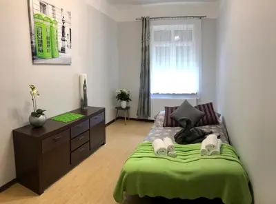 a bedroom with a green bed and a dresser at Apartment Family Krakow in Kraków