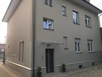 a large white building with two potted plants in front of it at Apartment Family Krakow in Kraków