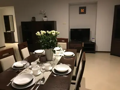 a dining room table with plates and a vase of flowers at Apartment Family Krakow in Kraków
