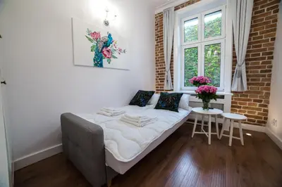 a bed in a room with a window and a table at Saint Philip in Kraków